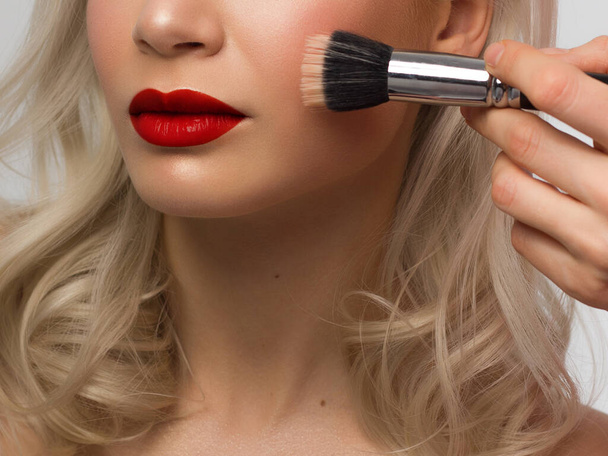 Sexual full lips. Natural gloss of lips and woman's skin. The mouth is closed. Increase in lips, cosmetology. red lipstick. Open mouth and with teeth. blonde hair. face powder on clean skin - Photo, Image