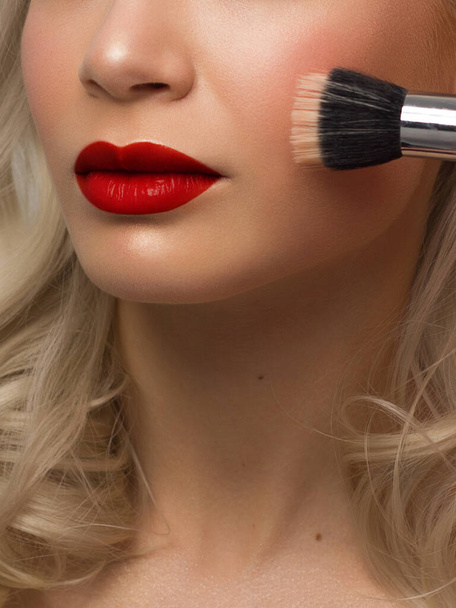 Sexual full lips. Natural gloss of lips and woman's skin. The mouth is closed. Increase in lips, cosmetology. red lipstick. Open mouth and with teeth. blonde hair. face powder on clean skin - Valokuva, kuva
