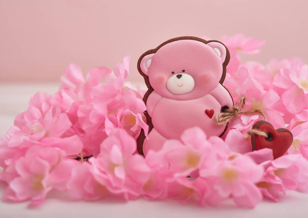 Valentinstagskekse in Pastellfarben. Lebkuchen tragen Plätzchen mit Blumen. Geburtstag, Frauentag oder Valentinstag Grußkarte Vorlage. Lebkuchen auf rosa Hintergrund. Süßes Geschenk - Foto, Bild