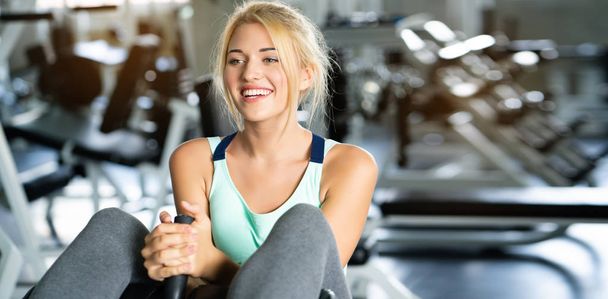 白人女性の幸せな笑顔。ジムやワークアウト機器でスポーツウェアを身に着けています。練習は健康なボディ、よい形を持ち、筋肉をよく弛緩させるのを助ける。ヘルスケアの概念 - 写真・画像