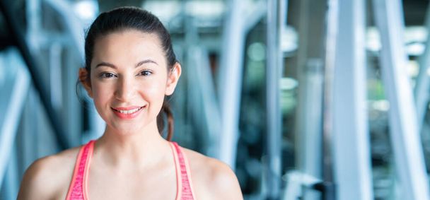 Jovem mulher asiática saudável com rosto sorridente. Vestindo roupas esportivas no ginásio e equipamentos de treino. Exercício ajuda a ter um corpo saudável, boa forma e relaxar os músculos bem. Conceitos de saúde
 - Foto, Imagem