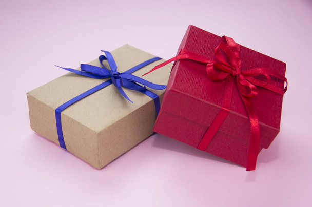 Geschenk mit blauer und roter Schleife auf rosa Hintergrund. Geschenkverpackung vorhanden. Dose mit Klebeband. - Foto, Bild