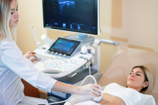 Ärztin führt Ultraschalluntersuchung der Patientin durch. - Foto, Bild