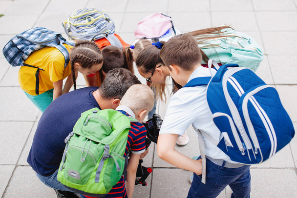Groupe d'adolescents penchés en cercle. Vêtements multicolores, sacs à dos. - Photo, image