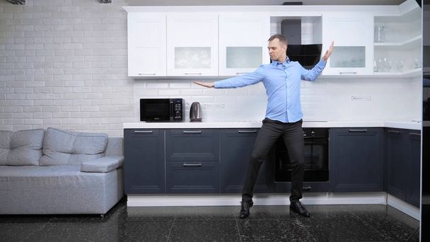 Genç yakışıklı adam mutfakta dans ediyor. Yaşam biçimi - Fotoğraf, Görsel