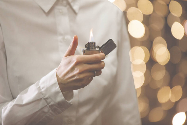 Woman in a white shirt with a lighter in hand - Photo, Image