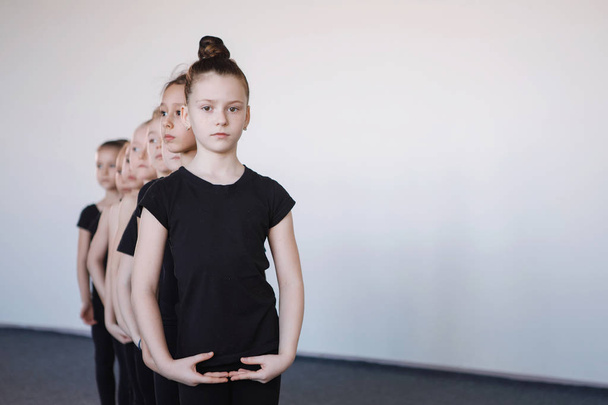 黒タイツの10代の女の子がダンス、バレエ、またはリズミカルな体操クラスで列に立つ. - 写真・画像