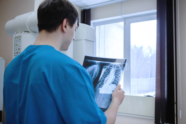 Radiologe untersucht Röntgenbilder in Arztpraxis. - Foto, Bild
