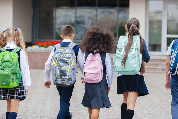 Üniformalı ve sırt çantalı öğrenciler okula gider.. - Fotoğraf, Görsel