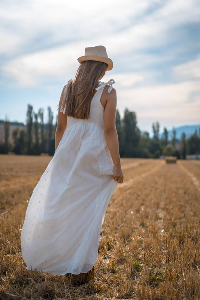 retrato de bela jovem mulher vestindo vestido branco no campo rural
 - Foto, Imagem