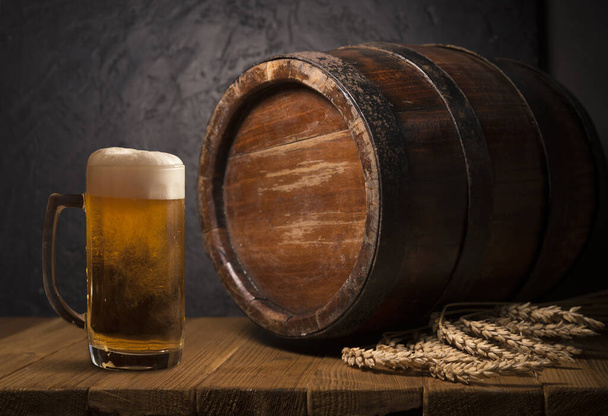 Стеклянное пиво с хмелевыми шишками и пшеничными ушами на темном деревянном фоне. Концепция пивоварни. Фон для пива. вид сверху с местом для копирования
 - Фото, изображение