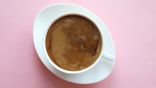 Процесс смешивания кофе и молока в чашке на розовом фоне, видео замедленной съемки
 - Кадры, видео