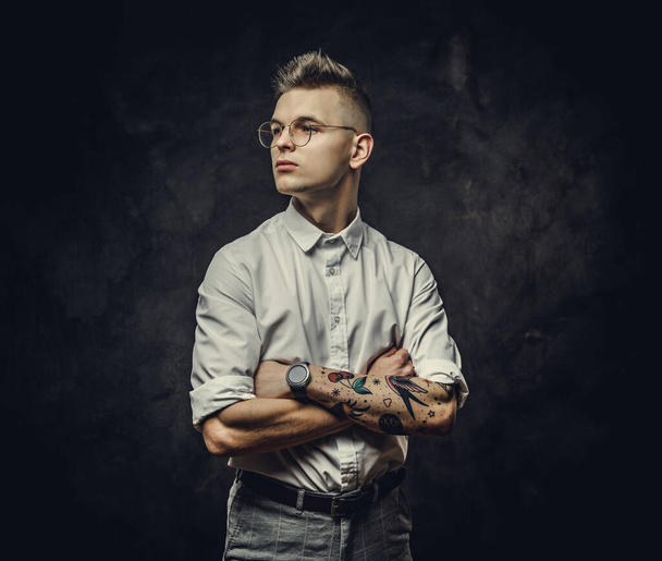 Elegante jovem adulto estudante do sexo masculino olhando pensativo posando em um estúdio, isolado em um fundo cinza
 - Foto, Imagem