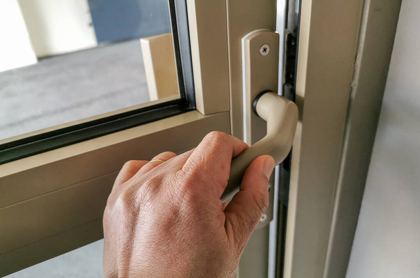 Una mano presionando una manija de la puerta para abrir o para cerrar la puerta
. - Foto, imagen
