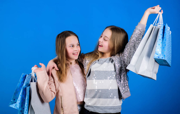 Kid fashion. Happy children. shop assistant with package. Sisterhood and family. savings on purchases. Small girls with shopping bags. Sales and discounts. Little girl sisters online shopping - Fotoğraf, Görsel