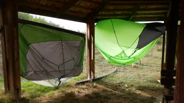 Natte tenten worden gedroogd na regen in de wind onder een luifel. - Video