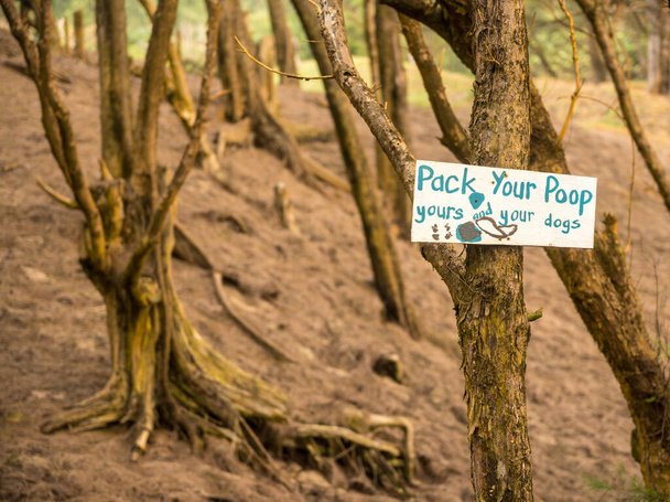 Empaca tu letrero de Poop en un bosque cerca de la playa en Hawaii
 - Foto, Imagen