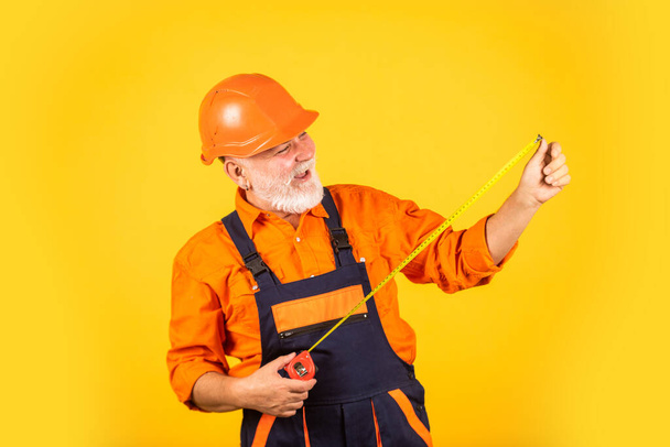 Confident worker. engineering and repair. happy carpenter. handyman measuring wall. senior builder use tape for measure. measurement. engineer size measuring. Construction man hold measuring tape - Photo, Image