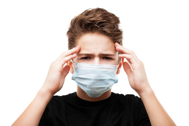 Human population virus, infection, flu disease prevention and industrial exhaust emissions protection concept - teenager boy wearing respiratory protective medical mask suffers headache white isolated - Foto, immagini