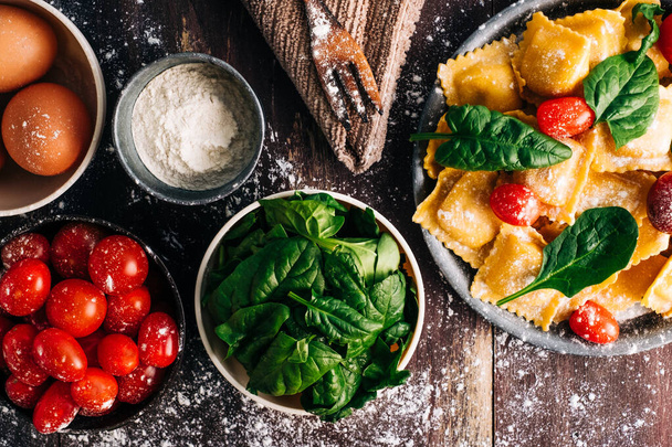 hausgemachte Ravioli gefüllt mit Spinat auf rustikalem Holztisch. Gesunde Ernährung, italienisches Essen. - Foto, Bild