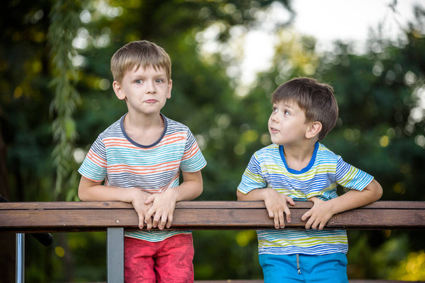 Двоє дітей у пішохідному туризмі стоять і дивляться на горизонт, оточений теплими сонячними кольорами. Концепція дружби між братами, щаслива сім'я
. - Фото, зображення