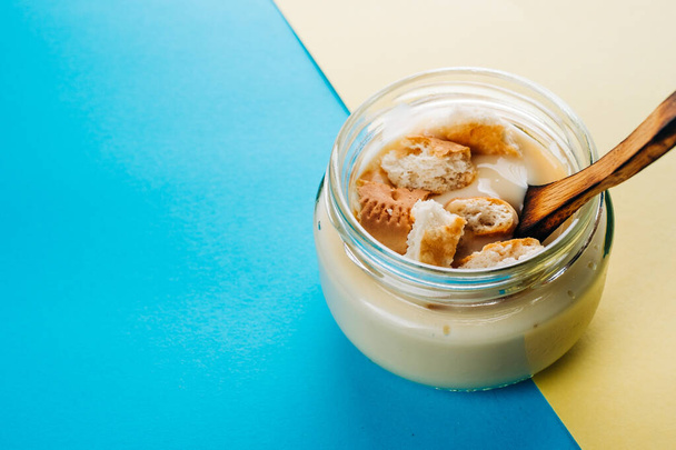 Vanilkový pudink s domácí sušenkou. Minimalistické modré a žluté pozadí - Fotografie, Obrázek