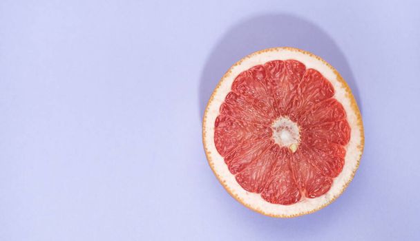 Grapefruitscheibe isoliert auf blauem Grund mit Schnittpfad und Schatten - Foto, Bild