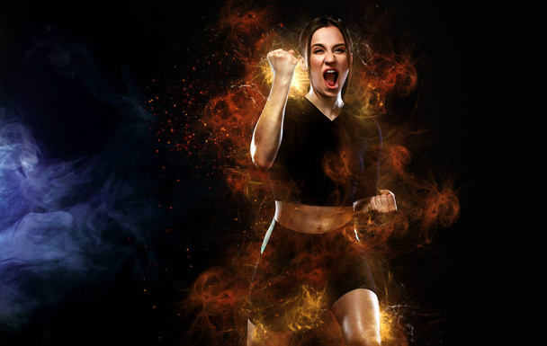 Sprinter and runner girl. Running concept. Fitness and sport motivation. Strong and fit athletic, woman sprinter or runner, running on black background in the fire wearing sportswear. - Photo, image