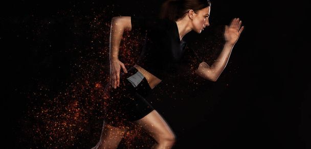 Sprinter and runner girl. Running concept. Fitness and sport motivation. Strong and fit athletic, woman sprinter or runner, running on black background in the fire wearing sportswear. - Fotografie, Obrázek
