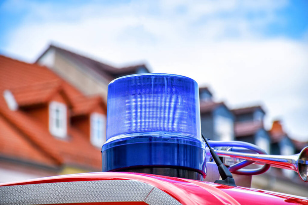 Vista dettagliata di un faro girevole blu sul tetto di un camion dei pompieri rosso
 - Foto, immagini