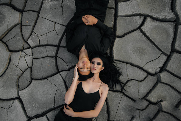 An Asian couple in love hugs while lying on the ground. Back background - Foto, afbeelding