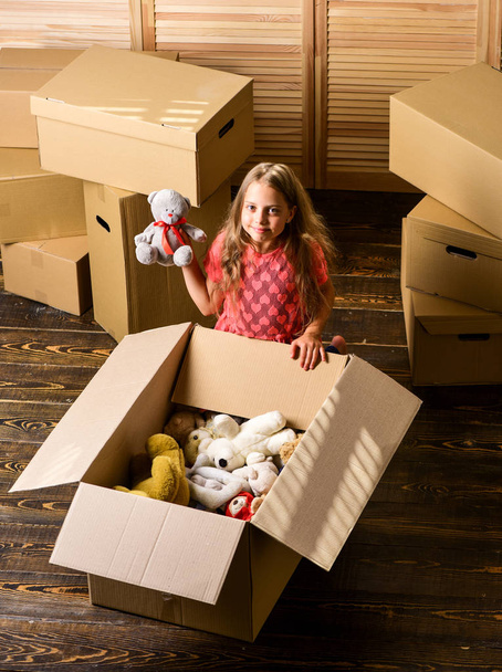 happy child cardboard box. happy little girl sit in room on boxes. purchase of new habitation. repair of room. new apartment. unpacking moving boxes. Cardboard boxes - moving to a new house - Foto, Imagem