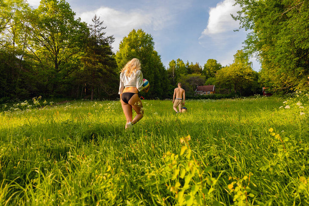 Jeune couple marchant sur l'herbe dans la forêt idyllique
 - Photo, image