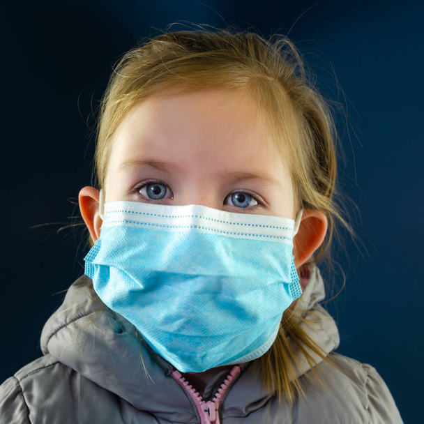 Pieni tyttö yllään suoja naamio käsitteellinen kuva koronavirus puhkeaminen
. - Valokuva, kuva