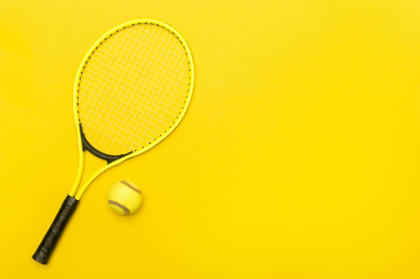 Вид зверху на тенісні ракетки і м'яч на жовтому тлі
.  - Фото, зображення