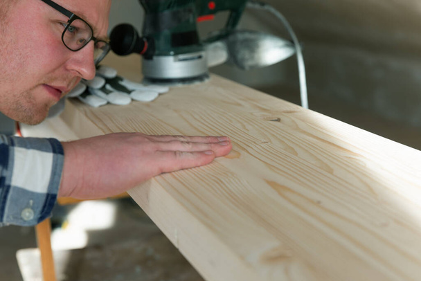 Carpentry. Wood sanding. Orbital sander for woodworking. In a natural light - Photo, Image