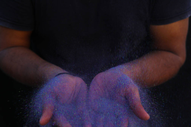 Canlı bir renk patlaması ile çevrili renkli holi tozunun el ele tutuşması. - Fotoğraf, Görsel