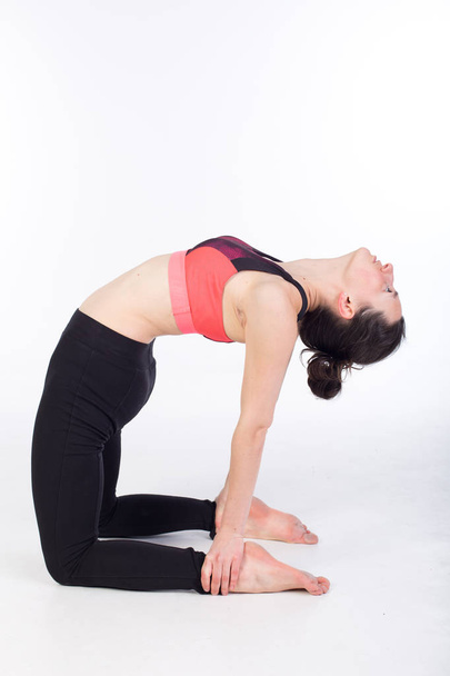 жінка в легінсах і спортивному бюстгальтері розтягується і практикує йогу
 - Фото, зображення