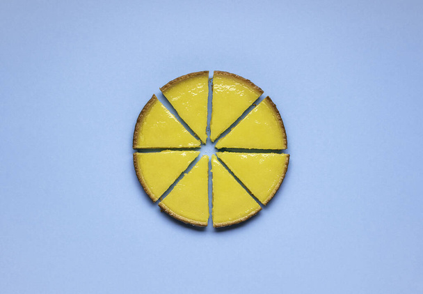Лимонный пирог нарезанный на синем фоне. Равный нарезанный лимонный пирог. Вкусная сладкая еда
. - Фото, изображение