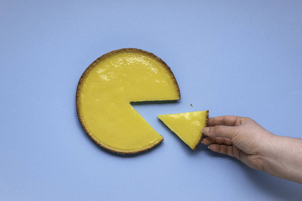 Citromos pite lapos feküdt a kék háttér. Egyetlen szelet citromos pite. Szeletelt citromlepény. - Fotó, kép