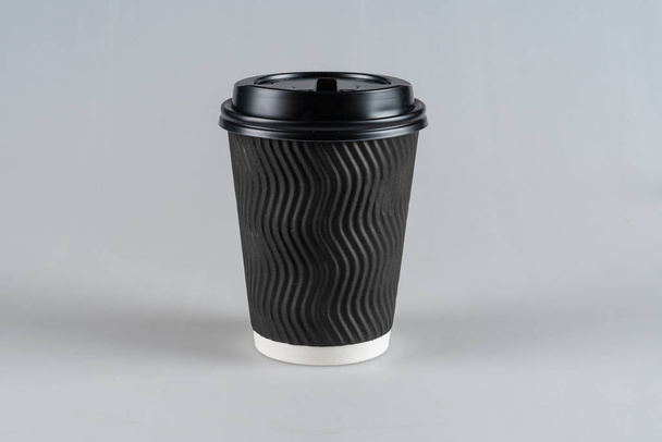 Jednorázové, kartónové černé pohár s černým víčkem, izolované na bílém pozadí. - Fotografie, Obrázek