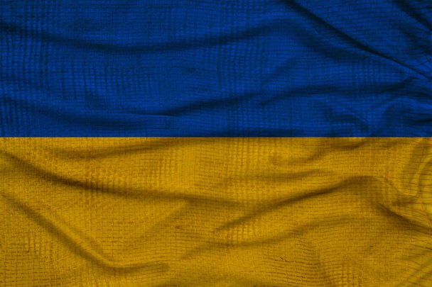 photo of the beautiful colored national flag of the modern state of Ukraine on textured fabric, concept of tourism, emigration, economics and politics, closeup - Foto, afbeelding