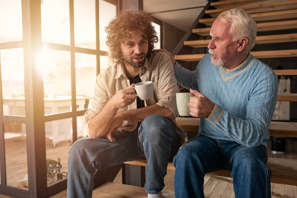 Отец и сын пьют кофе вместе. Концепция семейных отношений
 - Фото, изображение