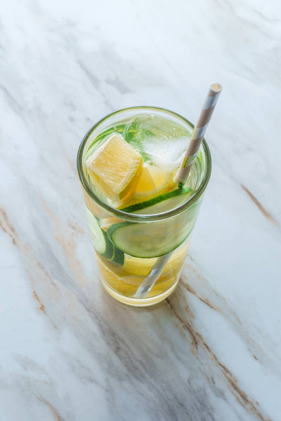Paper straw in cucumber lemon glass of water with ice - Valokuva, kuva