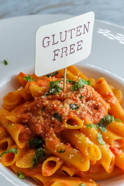 Gluten-free penne pasta in creamy vodka tomato sauce to be eaten by someone with celiac disease - Photo, Image