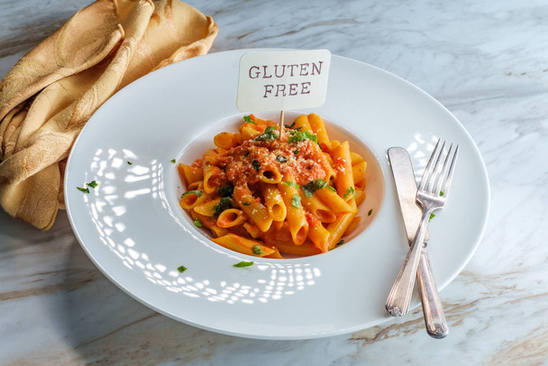 Gluten-free penne pasta in creamy vodka tomato sauce to be eaten by someone with celiac disease - Photo, Image