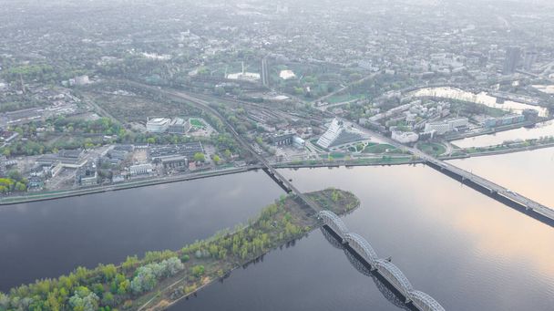 Fotografie z leteckého zobrazení z letícího bezpilotního panoramatického pohledu na mosty Rigy, řeku Daugavu, televizní věž a panorama města za slunečného letního dne v lotyšské Rize. (série) - Fotografie, Obrázek