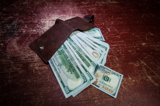 Stylová pánská kabelka s penězi na dřevěném pozadí. pánská kabelka s penězmi, kreditními a debetními kartami na dřevěném stole - Fotografie, Obrázek