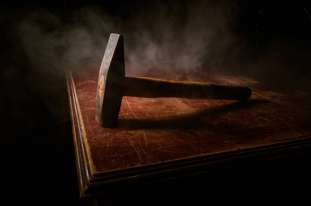 Vecchio martello vintage su un tavolo di legno di fronte a uno sfondo scuro tonico nebbioso. Focus selettivo
. - Foto, immagini