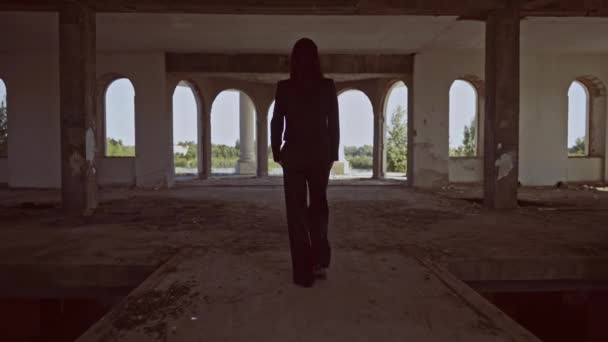 back view brunette walks in forsaken building - Video, Çekim